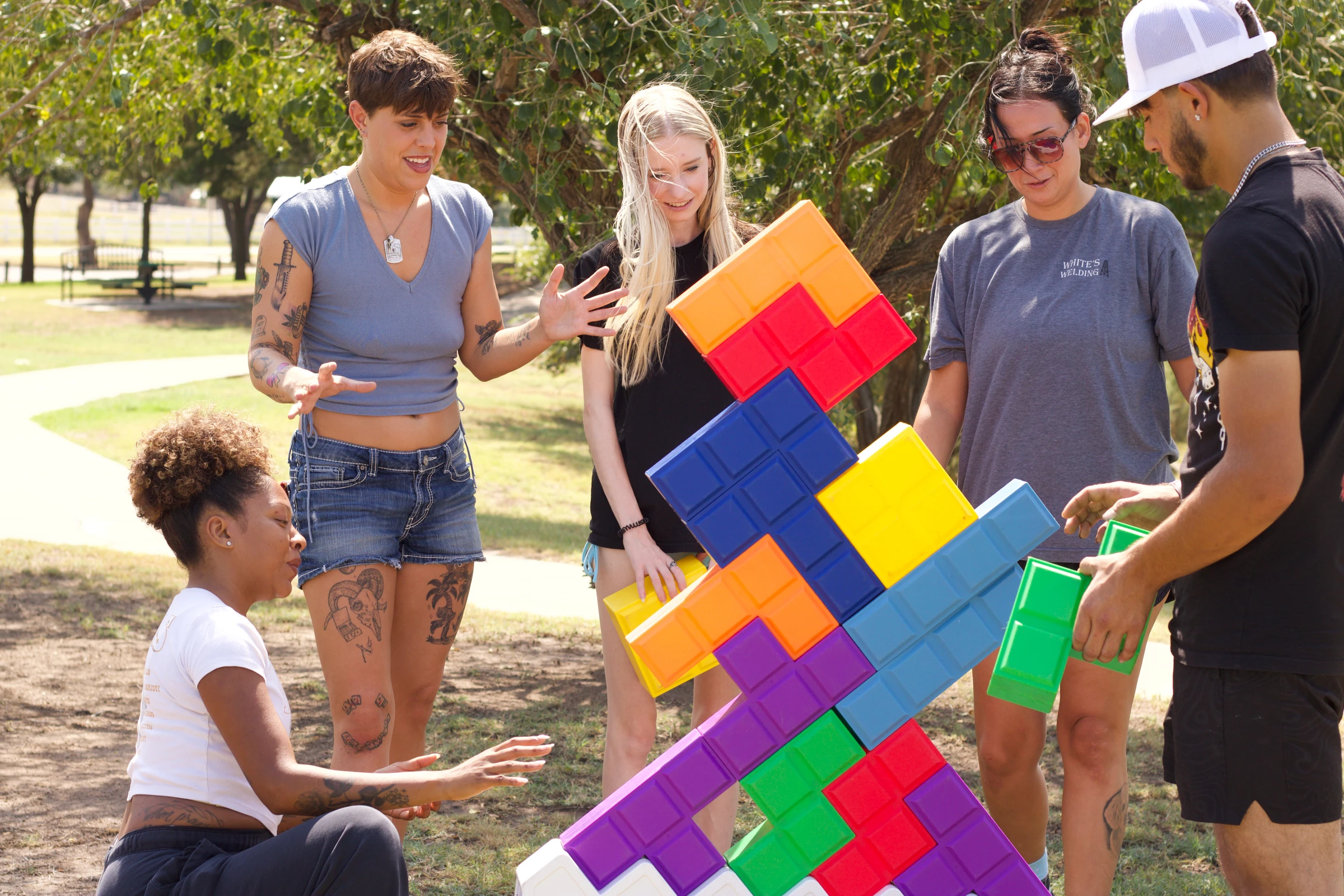 Teammates work together on a bright tower of giant Tetris blocks.