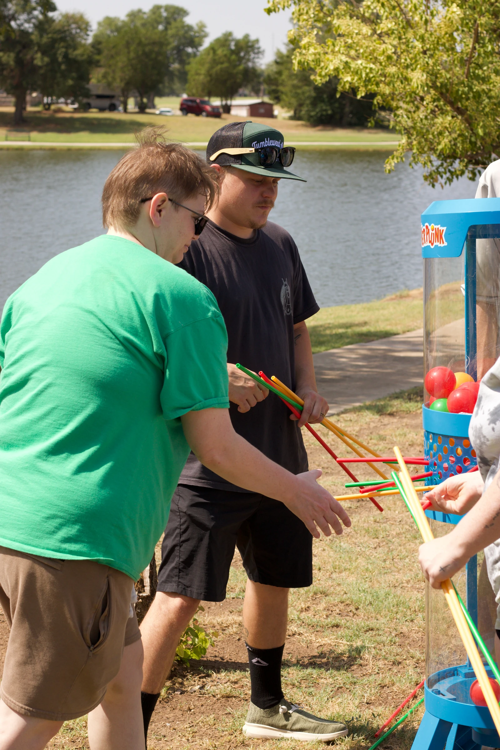 Players carefully pull rods from the giant KerPlunk game.